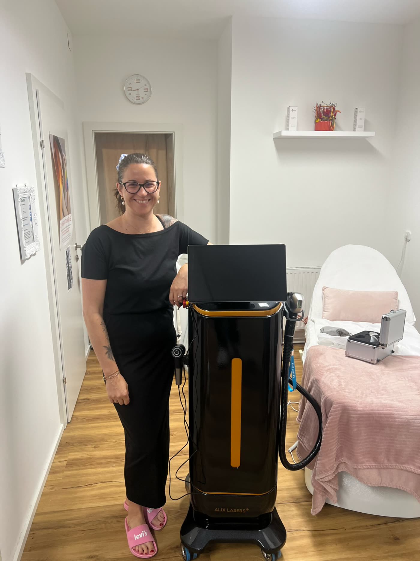 Kundin mit schwarzem Alix Lasers System im Behandlungszimmer