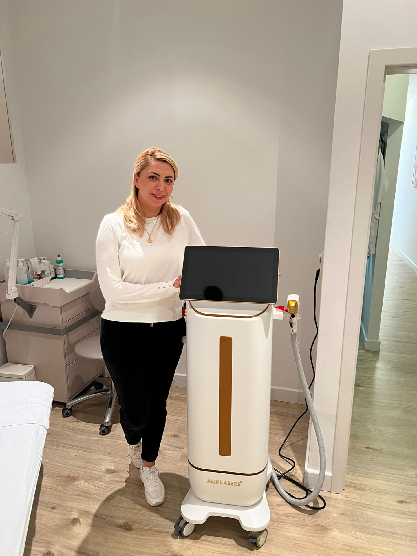 Kundin mit weiß-goldenem Alix Lasers System im Studio