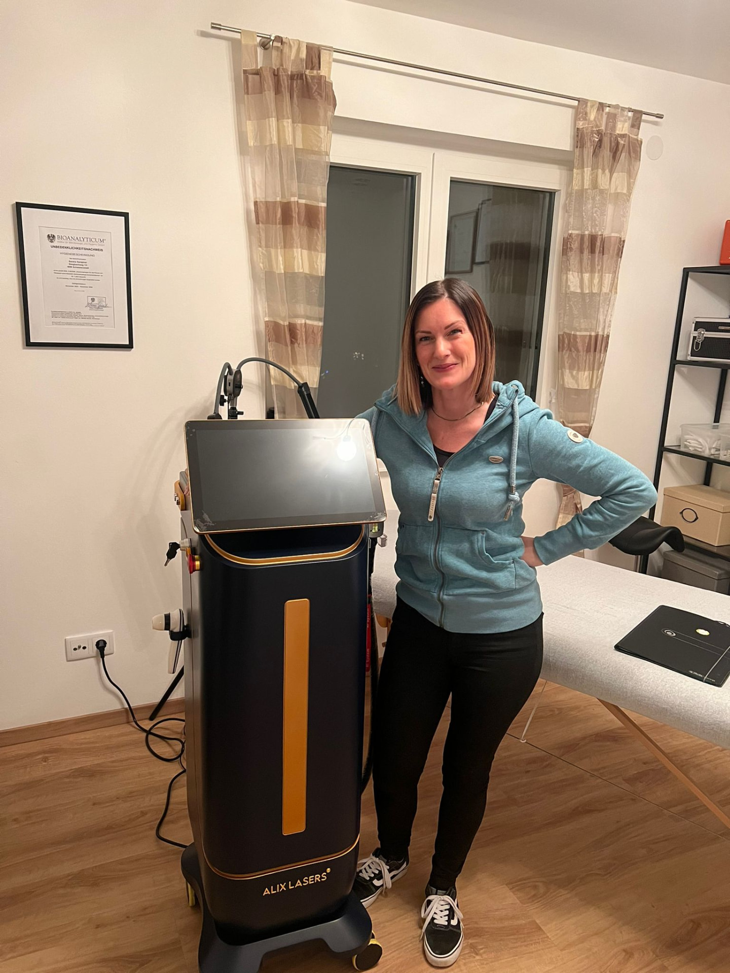 Kundin mit schwarz-goldenem Alix Lasers System im Behandlungsraum